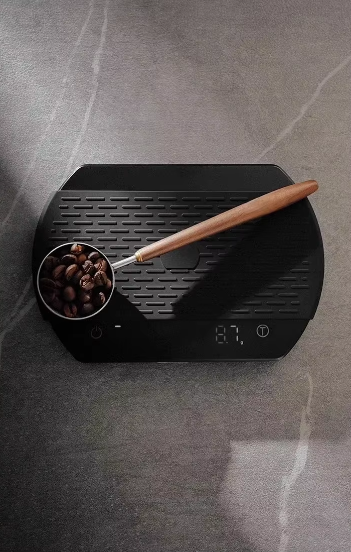 Sleek Wooden And Stainless Steel Metal Coffee Scoop On Scale Weighing Coffee Beans To Brew Lattes At Home In Luxury Style