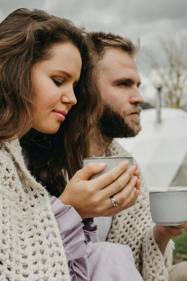 A couple enjoying hot Rishi's Turmeric Ginger Tea outside in the fall with blankets