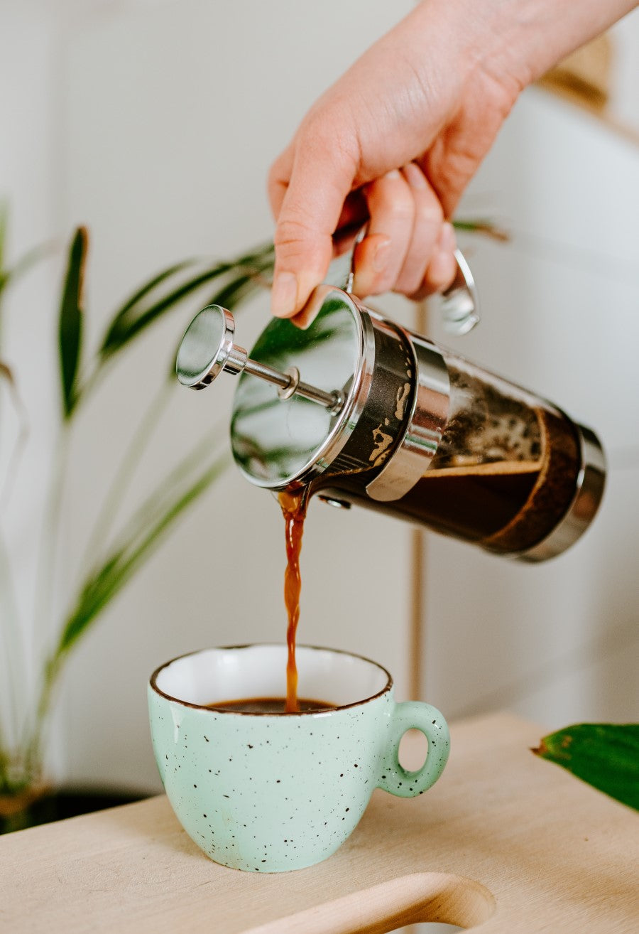 Pouring Dark Roast Italian Coffee From French Press Into Light Green Cup